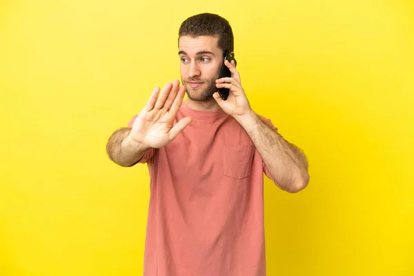 Handsome Blonde Man Using Mobile Phone Isolated Background Making Stop — Zdjęcie stockowe