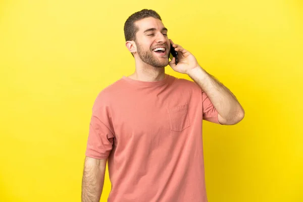 Przystojny Blondynka Człowiek Pomocą Telefonu Komórkowego Odosobnionym Tle Śmiech — Zdjęcie stockowe