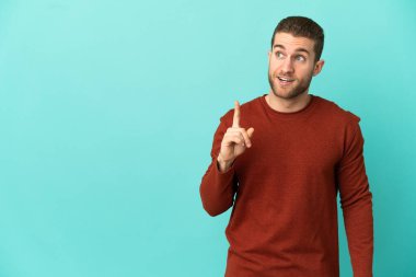 Sarışın, soyutlanmış, mavi arka planda yakışıklı bir adam.