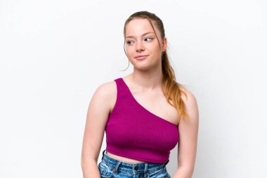 Beyaz arka planda karate yapan genç beyaz bir kız bir ürün sunmak için kenarı işaret ediyor.