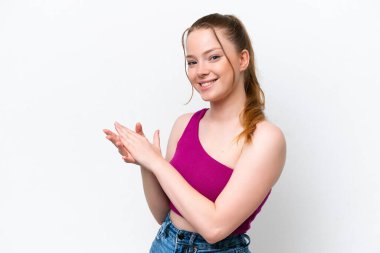 Beyaz arka planda karate yapan genç beyaz bir kız bir ürün sunmak için kenarı işaret ediyor.