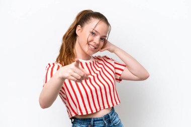 Beyaz arka planda karate yapan genç beyaz bir kız bir ürün sunmak için kenarı işaret ediyor.