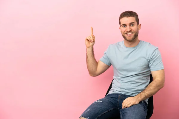 Jeune Homme Assis Sur Une Chaise Sur Fond Rose Isolé — Photo