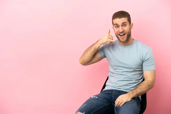 Young Man Sitting Chair Isolated Pink Background Making Phone Gesture — Stock fotografie