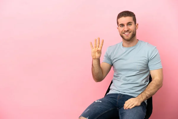 Young Man Sitting Chair Isolated Pink Background Happy Counting Four — Stock fotografie