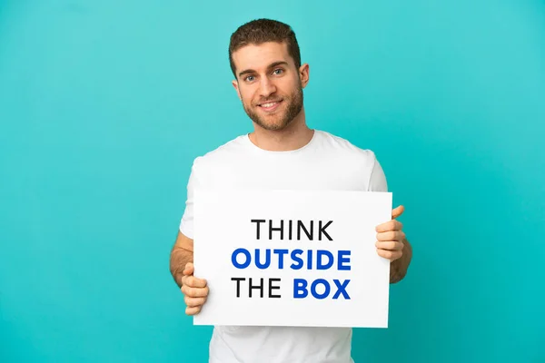Handsome Blonde Man Isolated Blue Background Holding Placard Text Think - Stock-foto