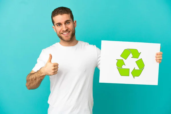 Handsome Blonde Man Isolated Blue Background Holding Placard Recycle Icon — ストック写真