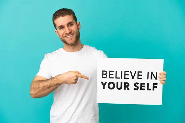 Handsome Blonde Man Isolated Blue Background Holding Placard Text Believe — Stock Photo, Image