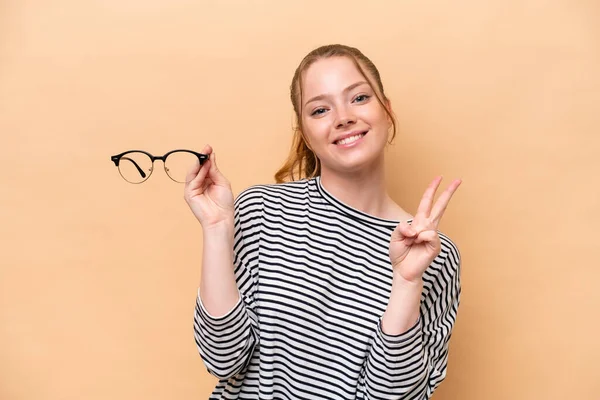 Young Caucasian Girl Glasses Isolated Beige Background Smiling Showing Victory — Photo