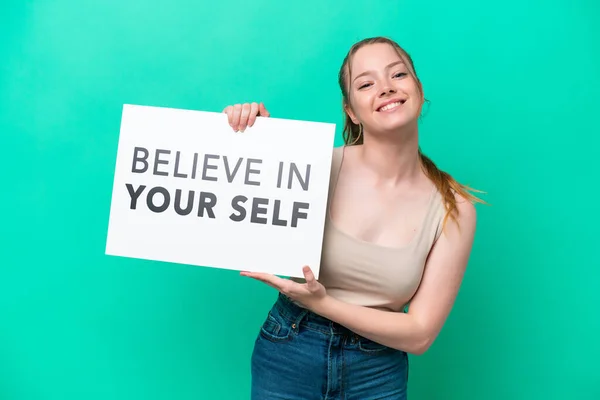 Young Caucasian Woman Isolated Green Background Holding Placard Text Believe — Zdjęcie stockowe