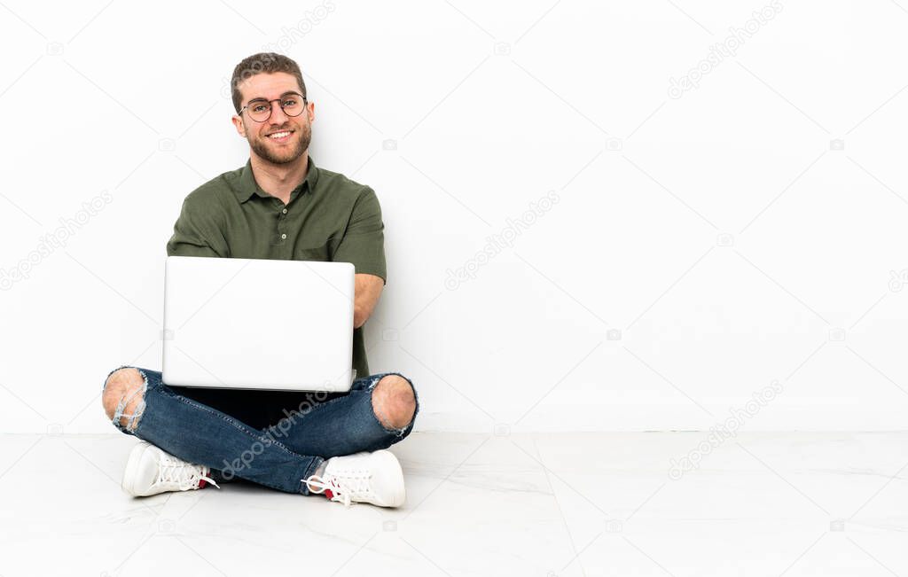 Young man sitting on the floor with arms crossed and looking forward