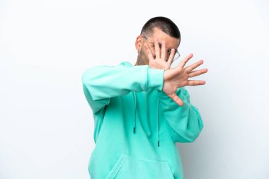 Beyaz arka planda izole edilmiş genç beyaz bir adam sinirleri gergin ve ellerini öne uzatıyor.