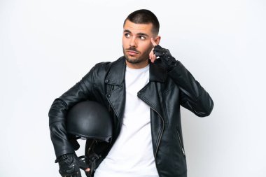 Motosiklet kasklı, beyaz arka planda izole edilmiş genç, beyaz bir adam. Şüpheleri ve düşünceleri var.