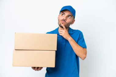 Teslimat beyaz arka planda izole edilmiş beyaz bir adam yukarı bakarken şüphe duyuyor
