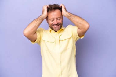 Mor arka planda izole edilmiş orta yaşlı beyaz bir adam gülüyor.