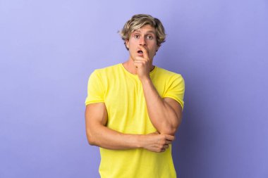 Münzevi mor arka planı olan İngiliz adam sağa bakarken şaşırdı ve şok oldu.