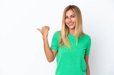 Sarışın Uruguaylı kız beyaz arka planda izole edilmiş bir ürün sunmak için yan tarafı işaret ediyor