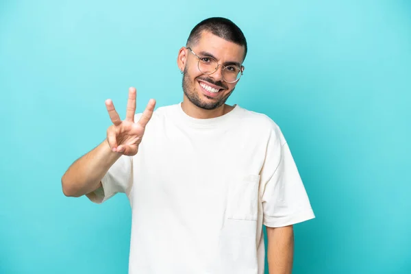 Mladý Běloch Izolovaný Modrém Pozadí Šťastný Počítání Tři Prsty — Stock fotografie