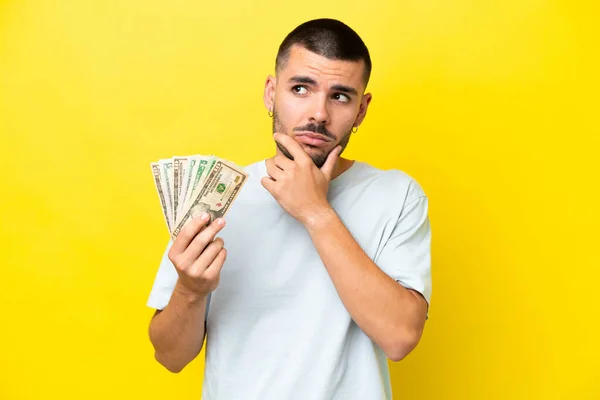 Jonge Kaukasische Man Neemt Veel Geld Geïsoleerd Gele Achtergrond Met — Stockfoto
