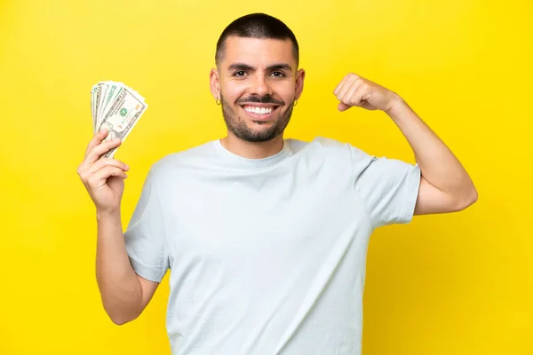 Young Caucasian Man Taking Lot Money Isolated Yellow Background Doing — Stockfoto