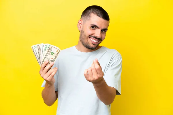 Young Caucasian Man Taking Lot Money Isolated Yellow Background Making — Stock Fotó