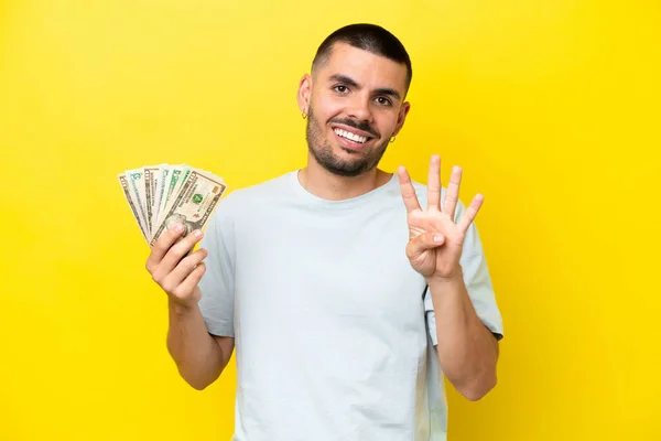 Young Caucasian Man Taking Lot Money Isolated Yellow Background Happy — Stockfoto