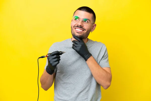 Tatuaje Artista Caucásico Hombre Aislado Sobre Fondo Amarillo Mirando Hacia —  Fotos de Stock