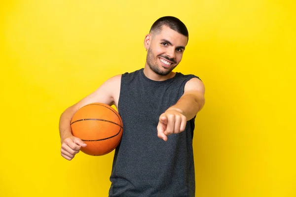 Молодий Білий Баскетболіст Ізольований Жовтому Тлі Вказуючи Спереду Щасливим Виразом — стокове фото