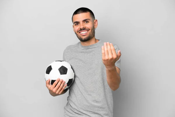 若いですサッカー選手男孤立しました上の灰色の背景にサッカーボールとやって来るジェスチャー — ストック写真