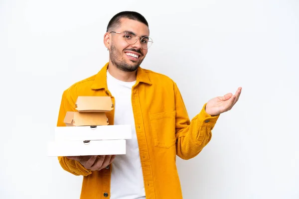 Mladý Kavkazský Muž Drží Pizzy Hamburgery Izolované Pozadí Natahuje Ruce — Stock fotografie