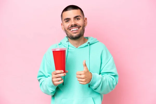 Young Caucasian Man Holding Soda Isolated Pink Background Giving Thumbs — 스톡 사진