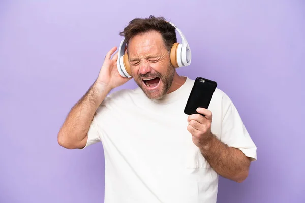 Homem Caucasiano Meia Idade Isolado Fundo Roxo Ouvindo Música Com — Fotografia de Stock