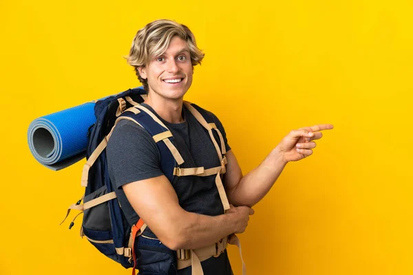 Young Mountaineer Man Isolated Yellow Background Pointing Finger Side — Foto Stock