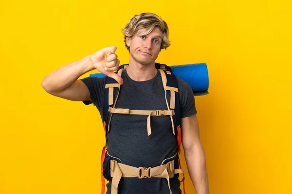 Young Mountaineer Man Isolated Yellow Background Showing Thumb Negative Expression — Stockfoto