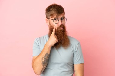 Pembe arka planda izole edilmiş genç, beyaz bir adam.