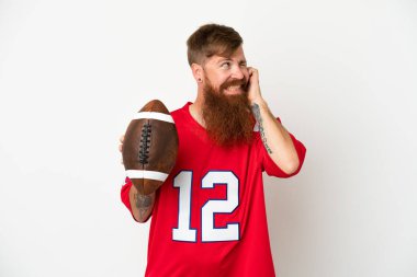 Beyaz arka planda ragbi oynayan Kafkasyalı genç adam hayal kırıklığına uğramış ve kulaklarını tıkamış.