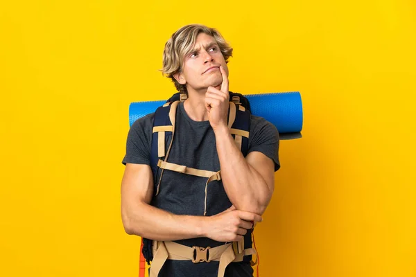 Young Mountaineer Man Isolated Yellow Background Having Doubts While Looking — Foto de Stock
