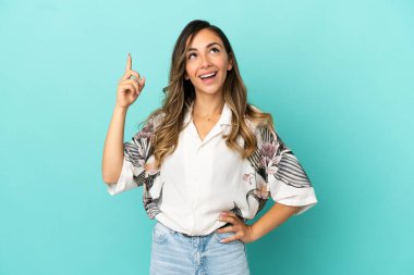Izole mavi arka plan üzerinde genç kadın işaret ve şaşırttı