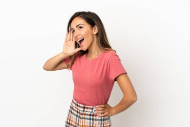 Izole arka plan üzerinde genç kadın kulak elini koyarak bir şey dinlerken