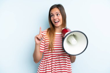 Mavi arka planda izole edilmiş genç beyaz kadın elinde bir megafonla çözümü bulmaya çalışıyor.