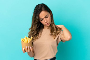 Kızarmış cipsleri izole edilmiş arka planda tutan genç bir kadın omuz ağrısından muzdarip.