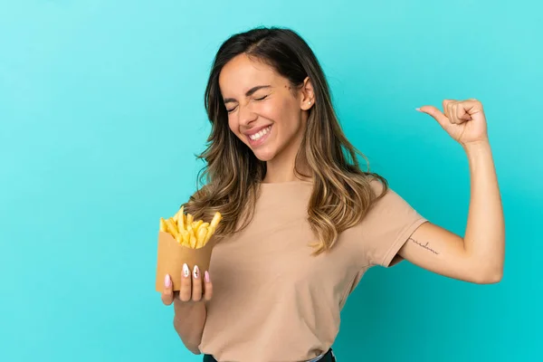 Young Woman Holding Fried Chips Isolated Background Doing Strong Gesture — Stock Fotó