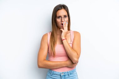 Beyaz arka planda izole genç beyaz kadın şaşırmış ve şok olmuştu.