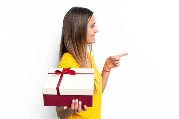 Jonge Blanke Vrouw Met Een Geschenk Geïsoleerd Witte Achtergrond Wijzend — Stockfoto