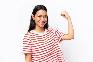 Beyaz arka planda izole edilmiş genç Kolombiyalı kadın güçlü bir hareket yapıyor.