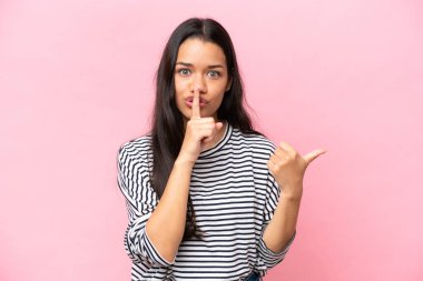 Pembe arka planda izole edilmiş genç Kolombiyalı bir kadın.