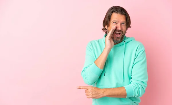 Senior Dutch Man Isolated Pink Background Pointing Side Present Product — ストック写真