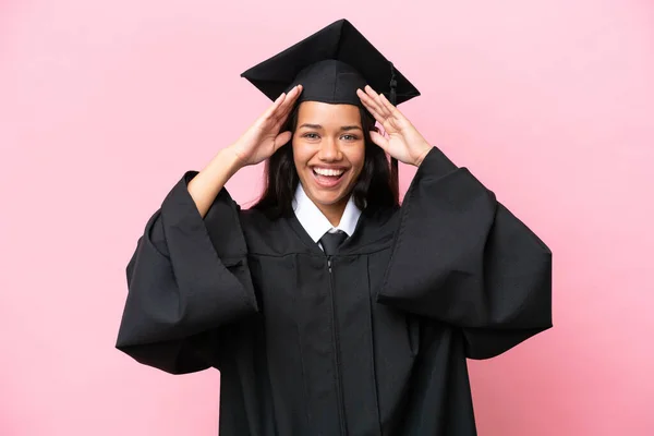 Young university Colombian woman graduate isolated on pink background with surprise expression