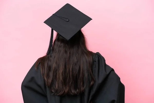 Young university Colombian woman graduate isolated on pink background in back position