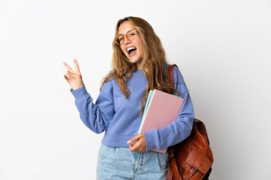 Beyaz arka planda izole genç bayan gülümseyerek ve zafer işareti göstererek